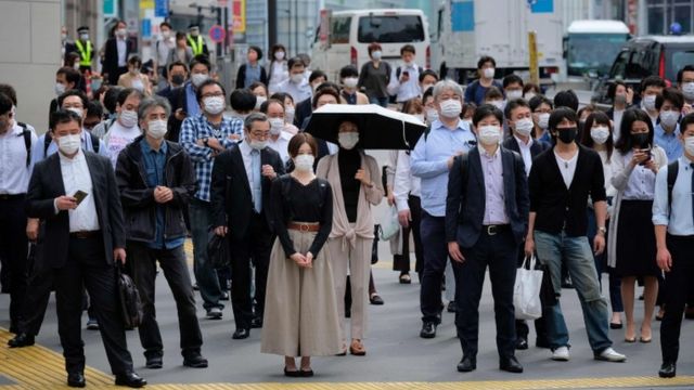 People wearing face masks amid concerns of the COVID-19 coronavirus commute in Tokyo on May 26, 2020.