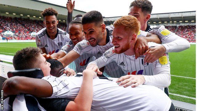 Rhys Porter is embraced by Fulham players