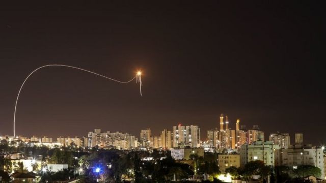 A streak of light is seen as Israel's Iron Dome intercepts rockets launched from the Gaza strip