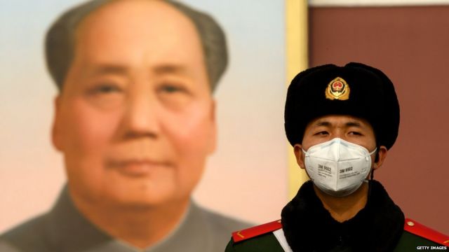 Полицейский охраняет портрет Мао Цзэдуна