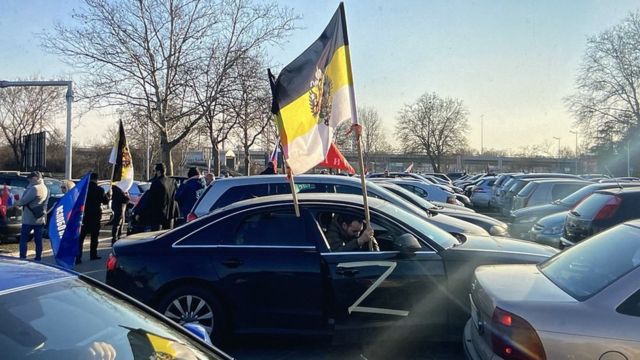 El conductor de un automóvil en Belgrado está agitando la bandera imperial rusa y tiene la letra Z en una puerta.