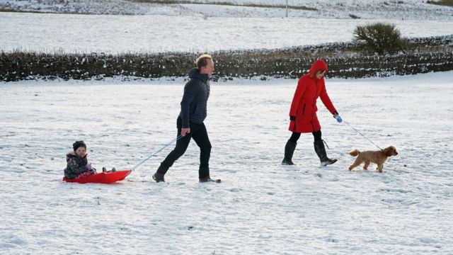 A family take advantage of the Christmas Day snow with a trip out sledging on the hills near Hexham, Northumberland.