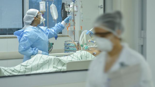 Profissionais de saúde trabalhando num leito de hospital