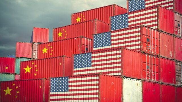 Contêineres empilhados estampando bandeiras dos EUA e China