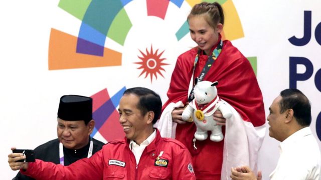Tổng thống Indonesia Joko Widodo chụp hình với huy chương vàng pencak silat Wewey Wita
