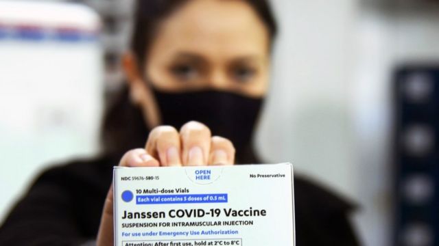 Mulher segura caixa com vacina da Janssen contra a covid-19 no Paraná