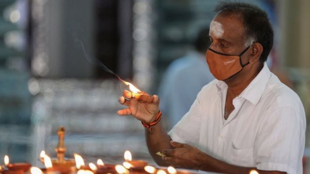 श्रीलङ्काको कोलम्बोस्थित हिन्दु मन्दिरमा दियो बाल्दै एक भक्तजन