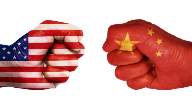 Manos con banderas de China y EE.UU.