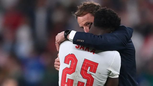 Técnico de futebol da Inglaterra Gareth Southgate abraçando jogador