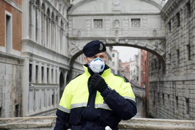 A local police officer wears a protective face mask during the Carnival in Venice, Italy, 23 February 2020