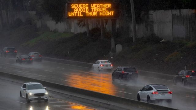 Highway in California with a sign warning of severe weather conditions through Thursday night.