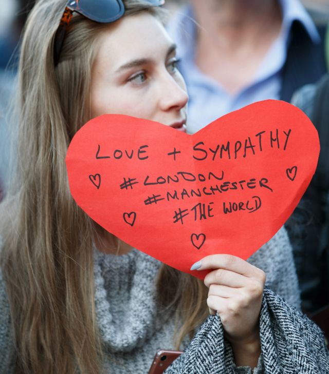 Жінка з написом "Любов + співчуття #Лондон #Манчестер #Цілий світ