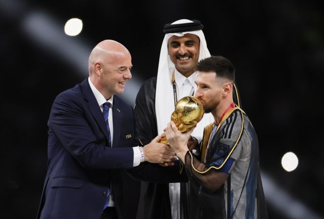 Messi accepts the World Cup, which he won in Qatar, with the FIFA President and the Qatari Emir at his side