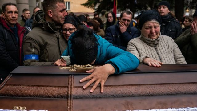 Familiares lloran por la muerte un soldado ucraniano en combate.