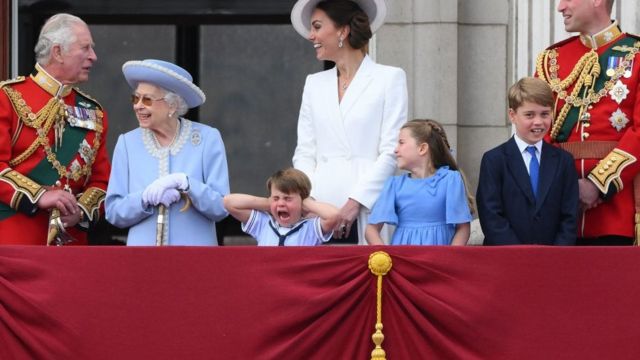 El príncipe Louis de Cambridge se tapa las orejas mientras está de pie junto a la reina Isabel II de Gran Bretaña, su madre Kate y sus hermanos para ver un vuelo especial desde el balcón del Palacio de Buckingham después del desfile por el cumpleaños de la reina.