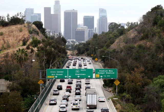 Kemacetan lalu lintas di jalan raya dengan latar belakang pusat kota Los Angeles.
