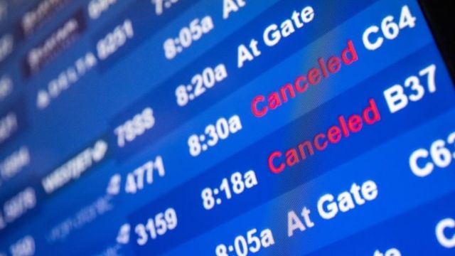 Un monitor de aeropuerto muentras varios vuelos cancelados