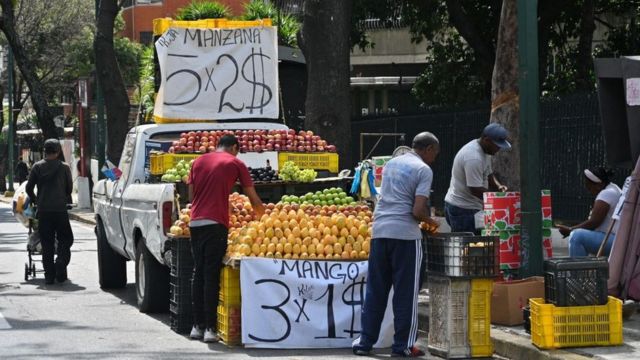 Un camión vende frutas en dólares.
