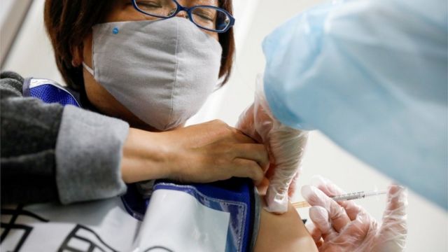 Japanese woman receiving vaccine jab