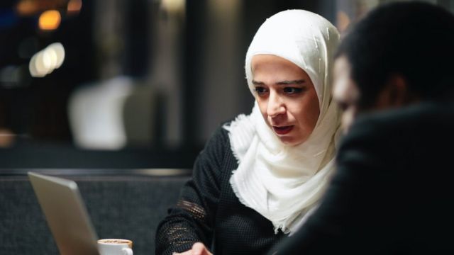 A woman and a man discuss something in an office