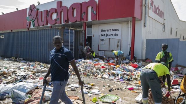 Des employés d'Auchan nettoient leurs magasins endommagés par des manifestants lors de manifestations après l'arrestation de l'opposant sénégalais Ousmane Sonko, le 06 mars 2021 à Dakar, au Sénégal.