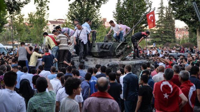 People gather on top of a Turkish military tank in Ankara