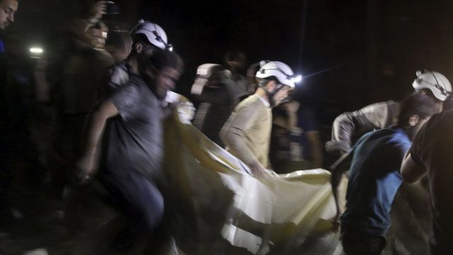 アレッポ空爆で負傷した人を運ぶ「ホワイト・ヘルメッツ」のメンバーら（27日）