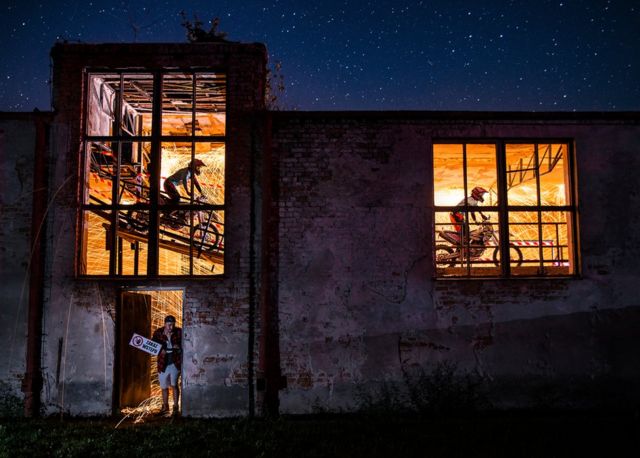 Cyclists through a warehouse window