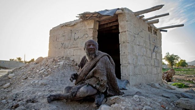 Amou Haji (tio Haji) senta-se em frente a um barraco de alvenaria aberto que os moradores construíram para ele, nos arredores da vila de Dezhgah, no distrito de Dehram, na província de Fars, no sudoeste iraniano, em 28 de dezembro de 2018.