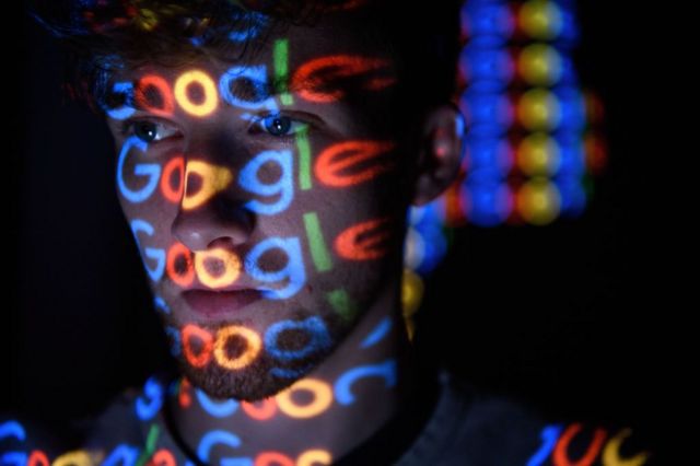 Una persona con proyecciones de la palabra Google en el rostro
