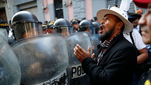 Un hombre grita a la policía cerca de las inmediaciones del congreso de Guatemala
