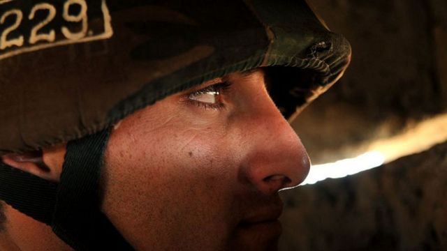 Un soldado mira por una rendija