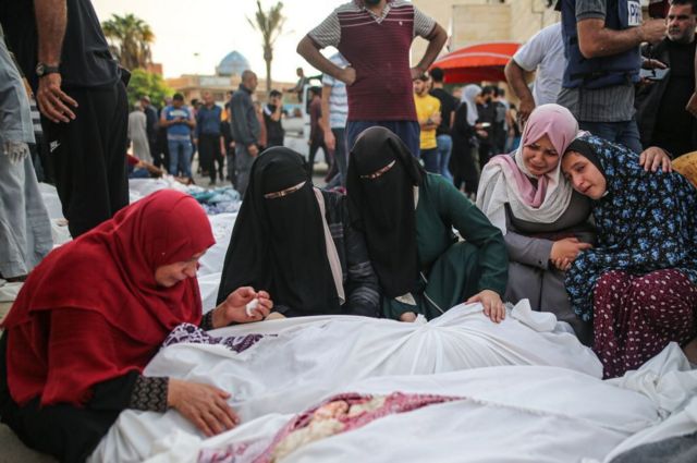 Mujeres lloran junto a cuerpos en el hospital Al Aqsa, en Deir Al Balah