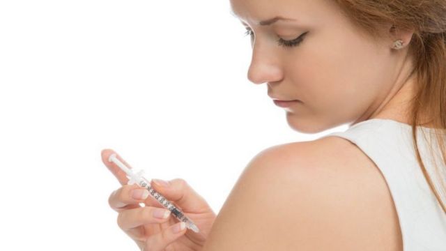 Mulher aplicando insulina em seu próprio braço