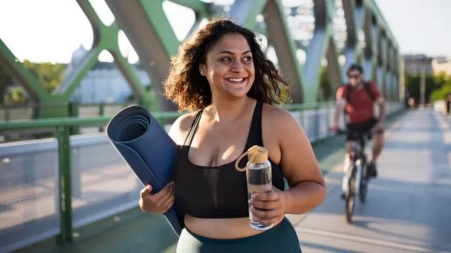 Brown girl in gym clothes holding water