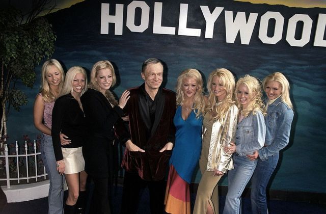 Varias Chicas Playboy posan junto a la figura de cera de Hugh Hefner en el Museo de Cera de Hollywood en 2021.