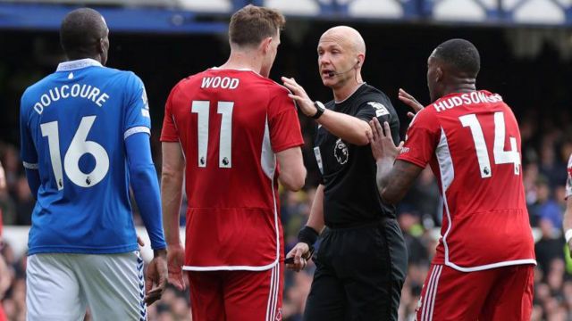 Referee Anthony Taylor is spoken to by Chris Wood and Callum Hudson-Odoi