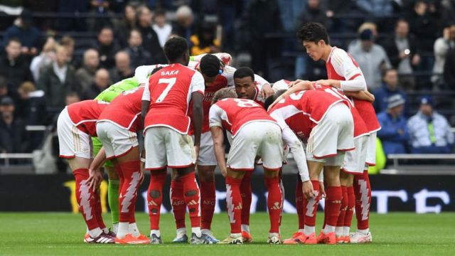 Arsenal players enter a huddle during the Premier League match against Tottenham