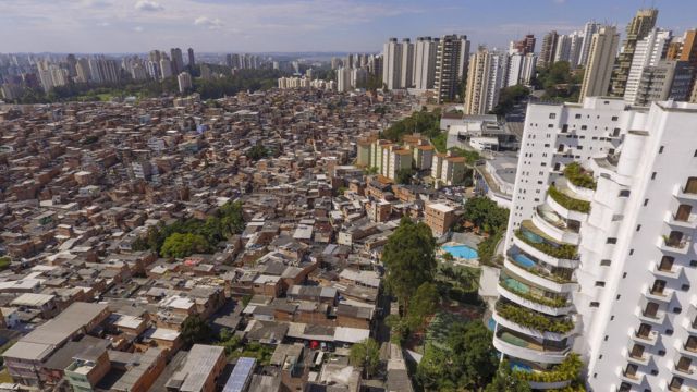 Prdio rico com piscinas na varanda ao lado da favela de Paraispolis, em So Paulo