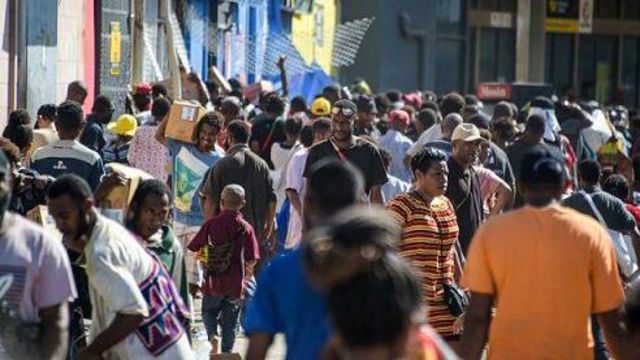 Orang-orang membawa barang jarahan dari toko-toko di tengah kerusuhan di Port Moresby pada 10 Januari 2024.