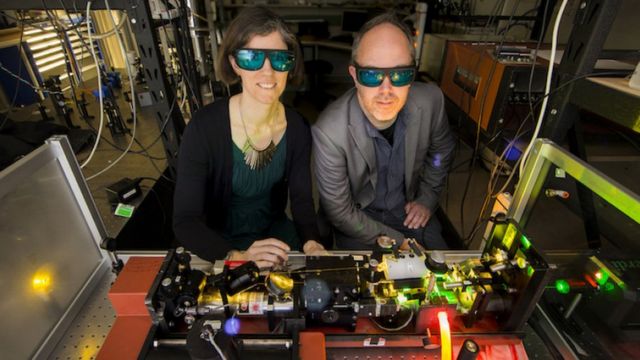 Rose Ahlefeldt y Matthew Sellars operando un láser de alta resolución para crear chips de memoria n la Universidad Nacional Australiana (ANU).