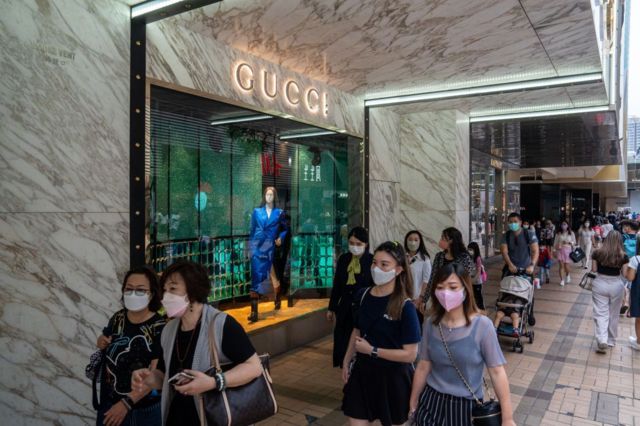 Chinos pasan frente a una tienda Gucci