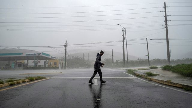 Un hombre parado frente a los fuertes vientos del huracán Fiona en Puerto Rico