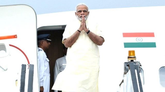 Indian Prime Minister Narendra Damodardas Modi standing out on aircraft folding his hands