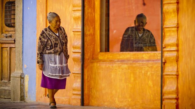 Mulher indígena caminha no centro histórico de Antigua, na Guatemala