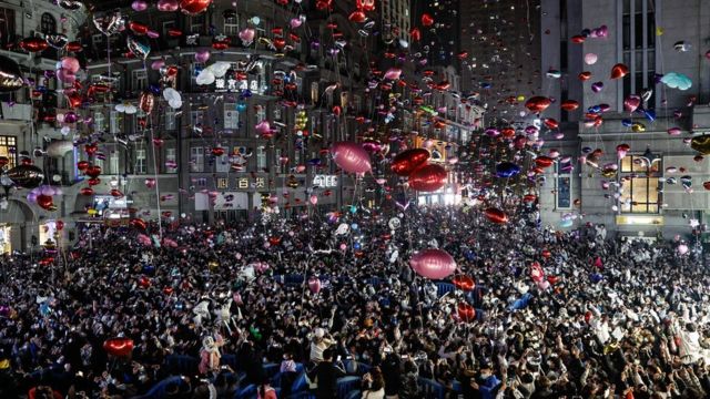 Revellers release balloons to celebrate the New Year on Jianghan Road, Wuhan on December 31, 2022