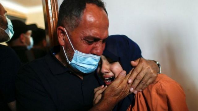 فلسطيني وعائلته يبكون قتلى سقطوا في غزة