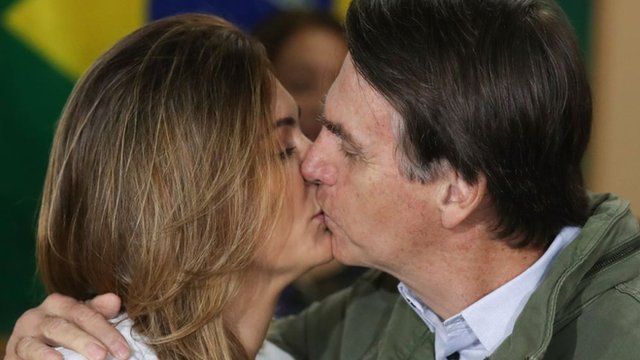 Michelle y Jair Bolsonaro se besan después de votar.