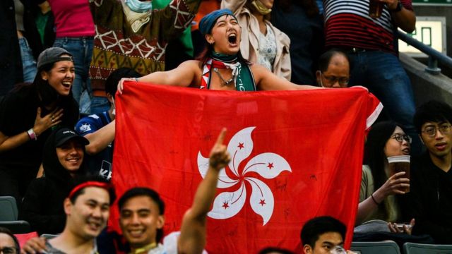 香港铜锣湾香港大球场举行的香港七人橄榄球赛上一位女观众举起中国香港区旗呐喊（4/11/2022）
