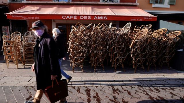 France lockdown - people walking by closed restaurant in Paris